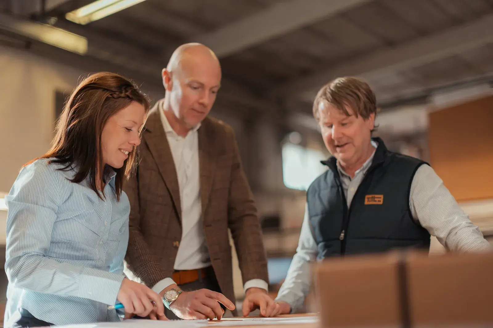 Three people looking at drawings on a table