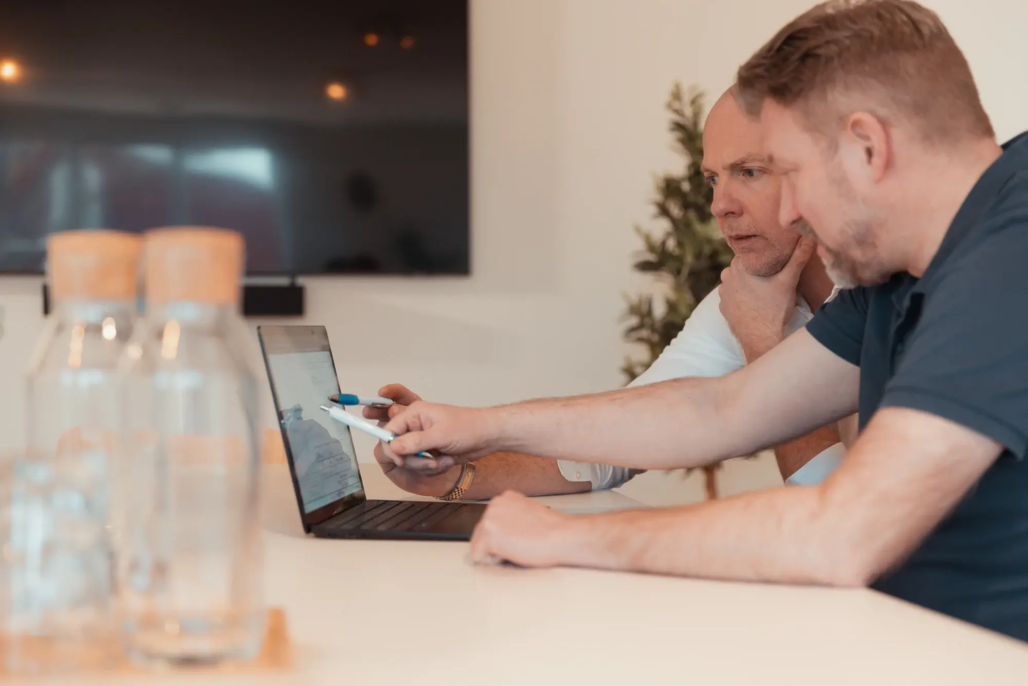 Two men working together in front of a computer